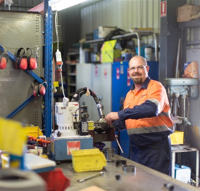 Technician servicing a hydraulic HUCK tool