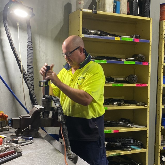 Technician servicing a hydraulic HUCK tool
